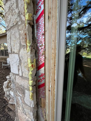 The side of a newly installed sliding patio door exposing the beams built to hold the door in place.