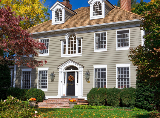 A large two story traditional house with a dormered roof.