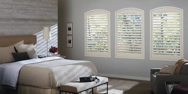 Hunter Douglas newstyle hybrid shutters in a bedroom in color swiss cream