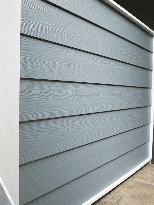 A show wall of traditional horizontal lap siding with a cedar finish. It is a baby blue color.