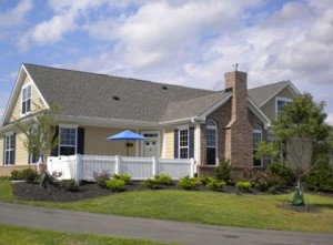 A single-story suburban home is shown with a white fence and a small yard.