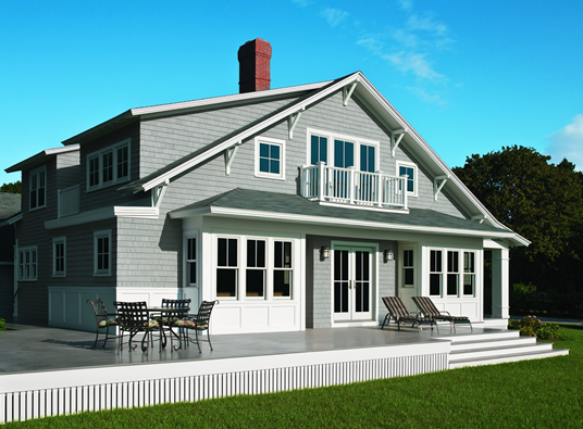 A house with grey siding, white trim and a red chimney.