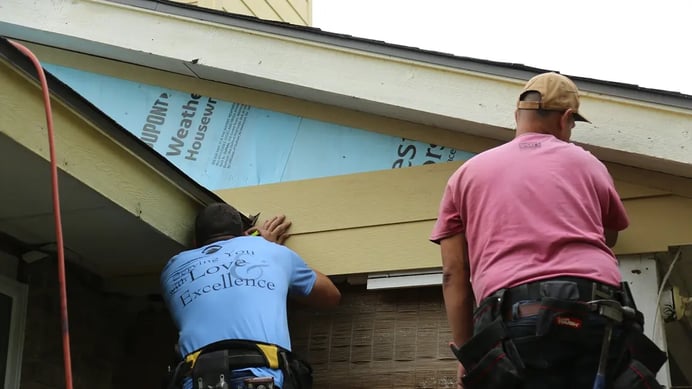 two men installing fiber cement siding